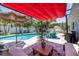 Tropical backyard featuring a patio area, in-ground pool, and lush landscaping at 1503 Albemarle Ct, Dunedin, FL 34698
