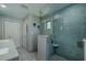 Bright bathroom featuring tile shower with glass door, double sink vanity, and storage at 1503 Albemarle Ct, Dunedin, FL 34698