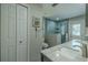 Bright bathroom with a double sink vanity, tiled shower with glass door, and backyard access at 1503 Albemarle Ct, Dunedin, FL 34698