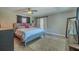 Bedroom featuring a sliding barn door, a ceiling fan, and a comfortable bed with wood floors at 1503 Albemarle Ct, Dunedin, FL 34698