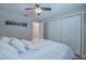 Cozy bedroom featuring a ceiling fan, and bright white closet doors at 1503 Albemarle Ct, Dunedin, FL 34698