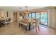 Open dining room featuring a wood table and bench with sliding glass doors to the outdoor pool at 1503 Albemarle Ct, Dunedin, FL 34698