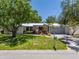 Beautiful home with a metal roof, lush landscaping, and a well-manicured lawn at 1503 Albemarle Ct, Dunedin, FL 34698