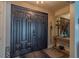 Inviting foyer featuring a dark double door, tile flooring, and console table with mirror at 1503 Albemarle Ct, Dunedin, FL 34698