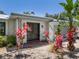 Charming home featuring a double door entrance with a front porch and tropical landscaping at 1503 Albemarle Ct, Dunedin, FL 34698
