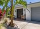 Charming front door entrance with well manicured landscaping and a rocking chair on the porch at 1503 Albemarle Ct, Dunedin, FL 34698