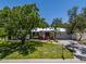 Charming single story home featuring a manicured lawn, lush landscaping, and a metal roof at 1503 Albemarle Ct, Dunedin, FL 34698
