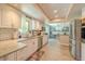 Bright kitchen featuring white cabinets, granite countertops, stainless appliances, and light wood flooring at 1503 Albemarle Ct, Dunedin, FL 34698