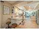 Open concept kitchen featuring an eat-in bar, white cabinets, granite countertops, and stainless appliances at 1503 Albemarle Ct, Dunedin, FL 34698