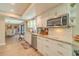 Bright kitchen featuring granite countertops, white cabinets, and an attached dining area and eat-in bar at 1503 Albemarle Ct, Dunedin, FL 34698