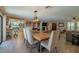 Open concept living and dining room featuring wood floors, a stone fireplace, and white accents at 1503 Albemarle Ct, Dunedin, FL 34698