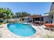 Inviting backyard oasis featuring a sparkling pool, lounge area, and lush landscaping for relaxation and entertaining at 1503 Albemarle Ct, Dunedin, FL 34698