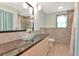Stylish bathroom features a granite countertop, vessel sink, tiled shower, and plenty of natural light at 1514 Florida Ave, Palm Harbor, FL 34683