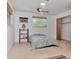 Bedroom featuring wood laminate flooring, a ceiling fan, and window-mounted air conditioner at 1514 Florida Ave, Palm Harbor, FL 34683