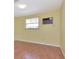 Simple bedroom featuring laminate floors, a window, and an air conditioning unit for added comfort at 1514 Florida Ave, Palm Harbor, FL 34683