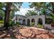 Single story home with white exterior, mature trees, and walkway with arches at 1514 Florida Ave, Palm Harbor, FL 34683