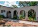 Single story home with white exterior, walkway with arches and mature trees at 1514 Florida Ave, Palm Harbor, FL 34683