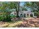 Single story home with arched walkway, lush landscaping and mature trees at 1514 Florida Ave, Palm Harbor, FL 34683