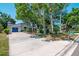 Charming single-story home featuring a well-manicured front yard, mature trees, and a blue garage door at 1514 Florida Ave, Palm Harbor, FL 34683