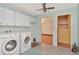 Well-lit laundry room with a washer, dryer, storage cabinets, and access to other parts of the house at 1514 Florida Ave, Palm Harbor, FL 34683