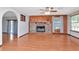 Bright living room featuring hardwood floors, stone fireplace, wood paneling, and large windows offering natural light at 1514 Florida Ave, Palm Harbor, FL 34683