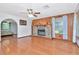 Spacious living room with a stone fireplace, wood paneling, hardwood floors, and a ceiling fan for added comfort at 1514 Florida Ave, Palm Harbor, FL 34683