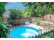 An inviting above ground pool sits amidst lush greenery and a wooden deck, creating a private oasis in the backyard at 1514 Florida Ave, Palm Harbor, FL 34683