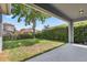 A covered back patio features a tree and green shrubbery at 15711 Starling Dale Ln, Lithia, FL 33547