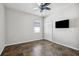 This bedroom features tile floors, a ceiling fan, closet and a television at 15711 Starling Dale Ln, Lithia, FL 33547