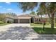 Charming home featuring a three-car garage, well-manicured landscaping, and a welcoming entrance at 15711 Starling Dale Ln, Lithia, FL 33547