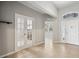 A bright foyer with glass paneled french doors and decorative glass above the front door at 15711 Starling Dale Ln, Lithia, FL 33547