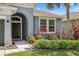 Charming home exterior with a lovely arched entry, well-maintained landscaping, and a palm tree at 15711 Starling Dale Ln, Lithia, FL 33547