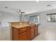 Beautiful kitchen island with granite countertops and brown cabinets overlooks the living area at 15711 Starling Dale Ln, Lithia, FL 33547