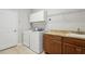 A laundry room features updated machines, shelving, and a utility sink at 15711 Starling Dale Ln, Lithia, FL 33547