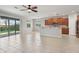 Open-concept living space with a spacious kitchen, tile flooring, and sliding glass doors to the backyard at 15711 Starling Dale Ln, Lithia, FL 33547