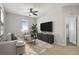 Well lit living room with stylish furniture and a modern entertainment center at 15711 Starling Dale Ln, Lithia, FL 33547