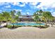 Community pool with plenty of lounge seating areas and many palm trees on a sunny day at 15711 Starling Dale Ln, Lithia, FL 33547
