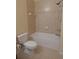 Bright bathroom featuring a tub with shower, neutral tile, and toilet at 16618 Kingletside Ct, Lithia, FL 33547