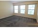 Bedroom showcasing three windows and neutral carpeting at 16618 Kingletside Ct, Lithia, FL 33547