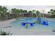 Resort-style community pool and splashpad with palm trees and outdoor seating at this luxurious community at 16618 Kingletside Ct, Lithia, FL 33547