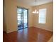 A naturally lit dining room features laminate flooring, a modern chandelier, and sliding door at 16618 Kingletside Ct, Lithia, FL 33547