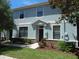 Front view of a blue townhome featuring well-maintained landscaping and a covered front entry at 16618 Kingletside Ct, Lithia, FL 33547