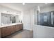 Bathroom featuring dual sinks, wood cabinetry, a glass shower and a toilet at 1897 Trailside Dr, Palm Harbor, FL 34683
