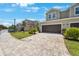 Beautiful townhome with a two-car garage and paver driveway on a sunny day at 1897 Trailside Dr, Palm Harbor, FL 34683