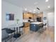 Open kitchen with a center island, dining area, and wood-look floors at 1897 Trailside Dr, Palm Harbor, FL 34683