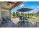Outdoor patio with a table, chairs, fan, and peaceful lake view at 1897 Trailside Dr, Palm Harbor, FL 34683