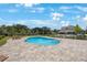Sparkling in-ground pool with paved patio and lounge chairs, perfect for relaxation and entertainment at 1897 Trailside Dr, Palm Harbor, FL 34683