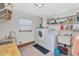 Efficient laundry room with washer, dryer, storage shelves, utility sink, and tile flooring at 1907 Sandpiper Dr, Clearwater, FL 33764