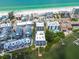 Panoramic aerial showcases beachfront condos with pool, private docks, and stunning ocean views at 19925 Gulf Blvd # 105, Indian Shores, FL 33785