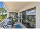 Balcony seating area with view of water and sky from sliding glass doors at 19925 Gulf Blvd # 105, Indian Shores, FL 33785